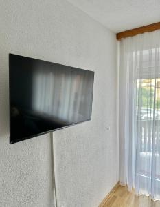 telewizor z płaskim ekranem wiszący na ścianie w pokoju w obiekcie Apartman Lara Laktasi w mieście Laktaši