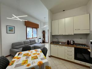 kuchnia i salon ze stołem i kanapą w obiekcie Millefonti House Lingotto w Turynie