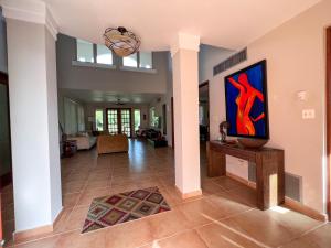 una sala de estar con una gran pintura en la pared en Villa Iris 2 story ocean view villa w/ pool access, en Vega Alta