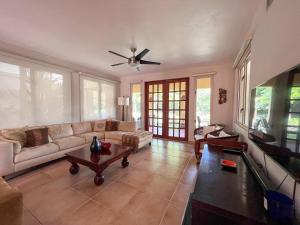a living room with a couch and a ceiling fan at Villa Iris 2 story ocean view villa w/ pool access in Vega Alta