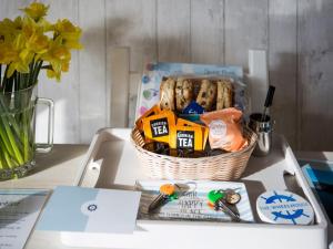a basket of snacks and bread on a table at The Wheelhouse in Fowey