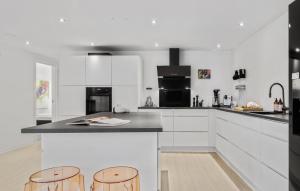 a kitchen with white cabinets and a counter with stools at Nice Apartment In Randers C With Wifi in Randers