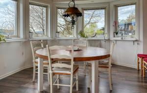 a dining room with a table and chairs and windows at Amazing Home In Uddevalla With Kitchen in Uddevalla