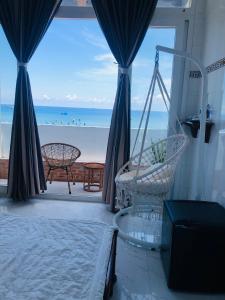 a bedroom with a hammock and a view of the beach at Khách sạn Hoàng Phú đảo Phú Quý in Cu Lao Thu