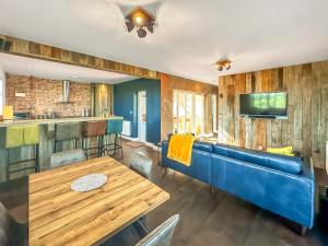 a dining room with a blue couch and a table at Valhallah Cottage Retreat in Broomhill