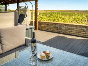 a bottle of wine and a plate of food on a table at Valhallah Cottage Retreat in Broomhill