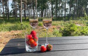 two glasses of wine and strawberries on a table at 3 Bedroom Lovely Home In Sffle in Säffle