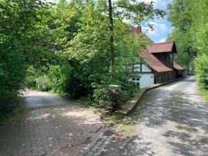 a cobblestone road next to a house at In der Wassermühle in Melle