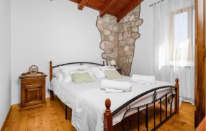 a bedroom with a bed and a stone wall at 4 Bedroom Stunning Home In Vlasici - Krsan in Kršan