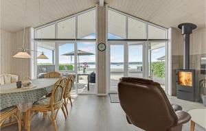 a dining room with a table and chairs and a fireplace at Holiday Home Sønderballevej Rødekro I in Diernæs