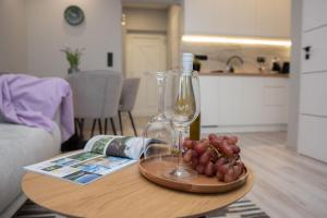 凱斯特海伊的住宿－Marina Luxury Aparment，一张桌子,上面放着一瓶葡萄酒和葡萄