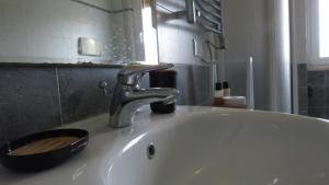 a bathroom sink with a faucet with a wooden bowl on it at BlueMind Freedom in Tropea +28 photos