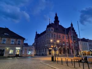 ein großes Gebäude in der Nacht auf einer Stadtstraße in der Unterkunft Gliwicka5 przy Rynku in Tarnowitz