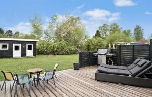 a deck with a grill and chairs and a table at Beautiful Home In Vig With Wifi in Vig