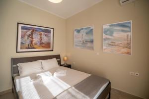 1 dormitorio con 1 cama con 3 cuadros en la pared en Tranquil Retreat in Apokoronas - Chania, en Kókkinon Khoríon