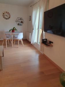 a living room with a table and a television at L'Obernois situé dans 1 résidence privée in Obernai