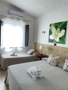 een hotelkamer met 2 bedden en een bloemenverf aan de muur bij B&B Villa Da Antonio in Caltanissetta