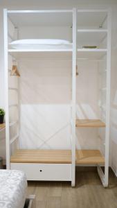 a white closet with wooden shelves in a room at Dimora del Pescatore - Holiday House in Cefalù