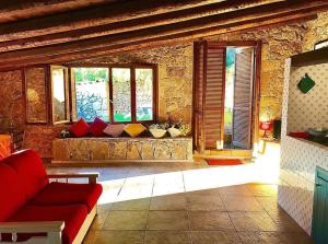 een woonkamer met een rode bank en een aantal ramen bij Blue Sea villa in Brucoli