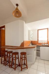 una cocina con 3 taburetes y una barra en SK studios & apartments, en Neo Klima