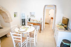 a kitchen and dining room with a table and chairs at Trulli del 1800 con Foresta, Wi-Fi e Biciclette in Cisternino