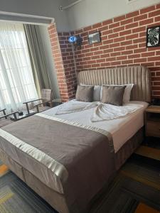 ディヤルバクルにあるSur Central Hotelのレンガの壁のベッドルーム1室(大型ベッド1台付)