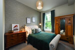 ein Schlafzimmer mit einem Bett, einer Kommode und einem Fenster in der Unterkunft Fairview Boutique Apartments in West Bridgford Centre in Nottingham