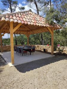 einem Holzpavillon mit einem Tisch und Stühlen darunter in der Unterkunft Villa Coronille calme et nature in Entrecasteaux