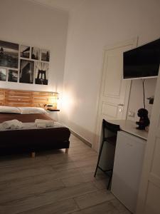 a bedroom with a bed and a desk with a television at LA CASA DEL RIONE SANITA’ in Naples