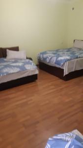 two beds in a room with a wooden floor at Luiza Guest House in Areni
