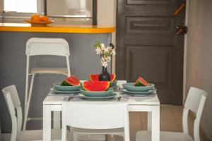 a table with bowls of fruit and a vase of flowers at Protaras O2 Seaside Suite in Protaras