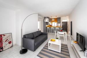 a living room with a couch and a kitchen at Protaras O2 Seaside Suite in Protaras