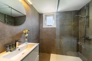 a bathroom with a sink and a shower and a mirror at Protaras O2 Seaside Suite in Protaras