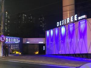um edifício com luzes roxas na lateral em Motel Desireé em São Paulo