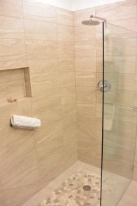 cabina de ducha con puerta de cristal en Karana 4 Bedroom, en Long Bay Hills