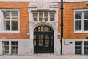 a black door on a brick building with windows at Sonder The Arts Council in London