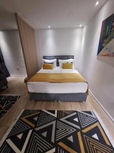 1 dormitorio con 1 cama grande con almohadas amarillas en Apartman Orhideja with Free Parking en Sarajevo