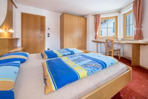 1 dormitorio con 1 cama grande con sábanas azules y amarillas en Residence Oberhauser Apt 4 en Valdaora di Sopra