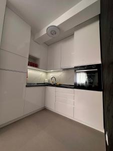 uma cozinha com armários brancos e um forno com placa de fogão em APARTMAN 3 em Brčko