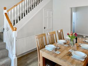 a dining room with a wooden table and chairs at April House in Amble