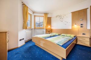 um quarto com uma cama com um tapete azul em Residence Oberhauser Apt 3 em Valdaora
