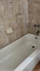 a white bath tub in a bathroom with a tile wall at U4 - Cozy 1BR & 1BA Walkup APT in DT PHX with pkg in Phoenix