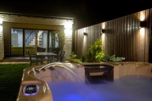 a bath tub in the yard of a house at night at Victoria Suites in Siófok