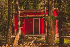 a red house in the middle of a forest at Villaflor Pousada in Vale do Capao