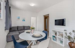 a living room with a white table and blue chairs at Cozy Apartment In Selce With Kitchen in Selce