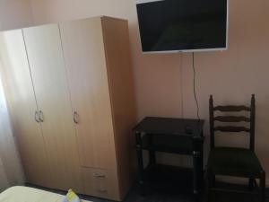 um quarto com uma secretária, uma televisão e uma cadeira em Вила Кичево em Varna