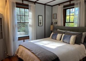 um quarto com uma cama grande e 2 janelas em Storybook Lake Front Villa with Private Beach! em Winchester