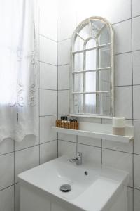 a white bathroom with a sink and a mirror at SK studios & apartments in Neo Klima