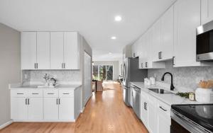 a kitchen with white cabinets and a wooden floor at Entire House Towson / Baltimore in Towson