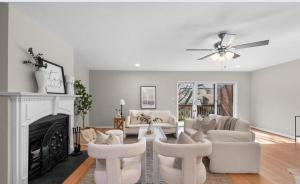a living room with white furniture and a fireplace at Entire House Towson / Baltimore in Towson